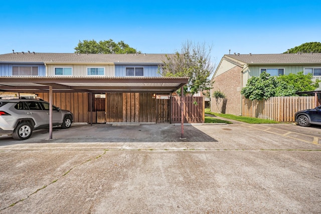 view of front of house featuring covered parking, fence, and board and batten siding