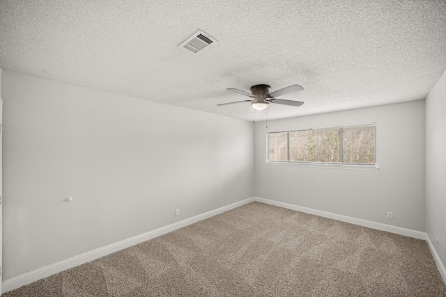 spare room featuring carpet flooring, a textured ceiling, ceiling fan, and visible vents