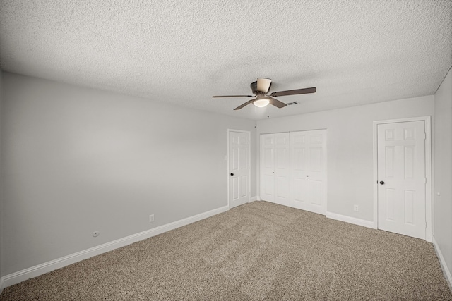 unfurnished bedroom with carpet floors, a closet, baseboards, ceiling fan, and a textured ceiling