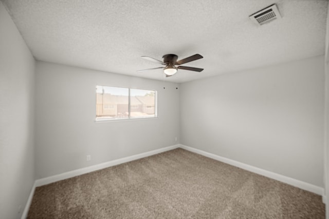 carpeted spare room featuring visible vents, a textured ceiling, baseboards, and ceiling fan