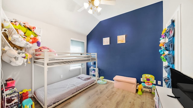 bedroom with baseboards, a ceiling fan, wood finished floors, and lofted ceiling
