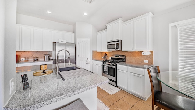 kitchen with recessed lighting, a sink, white cabinetry, and appliances with stainless steel finishes