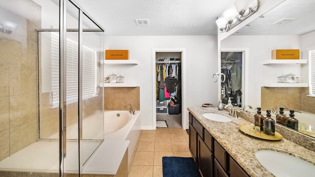 bathroom featuring a sink, tile patterned flooring, a shower stall, visible vents, and a garden tub