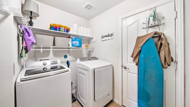 laundry area with visible vents, laundry area, light tile patterned flooring, and washer and dryer