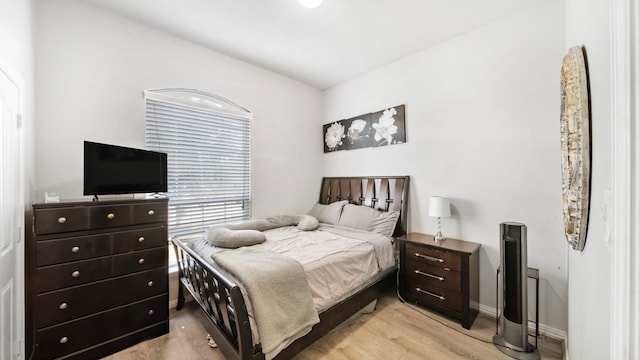 bedroom with baseboards and light wood-type flooring
