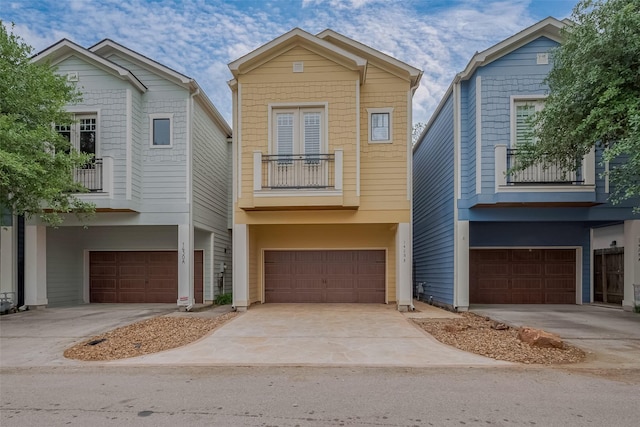 view of front of property with concrete driveway, an attached garage, and a balcony