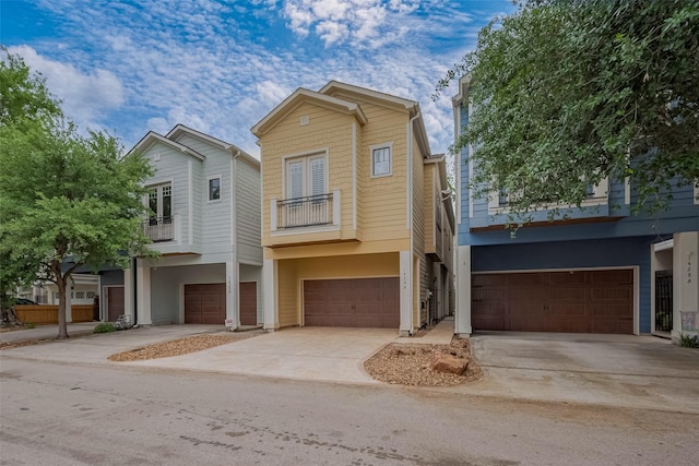view of front facade with an attached garage, a balcony, and concrete driveway