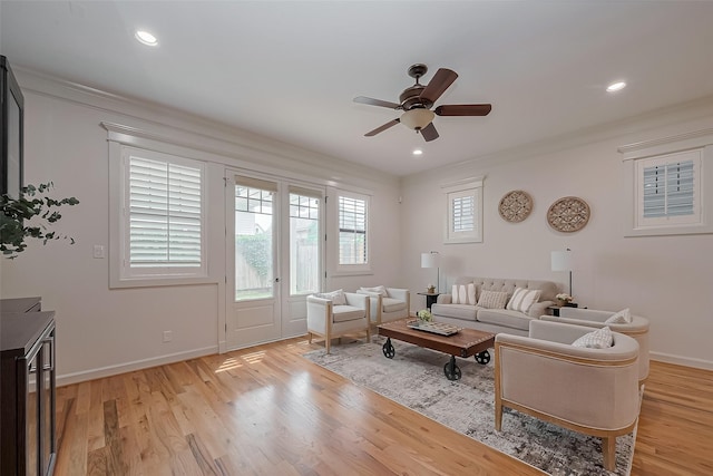 living room featuring baseboards, a ceiling fan, and light wood-type flooring