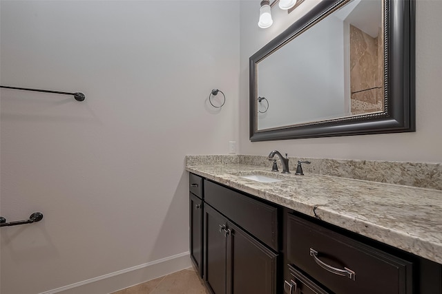 bathroom featuring baseboards, tile patterned floors, and vanity