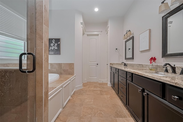 bathroom featuring double vanity, stone finish floor, a bath, a shower stall, and a sink