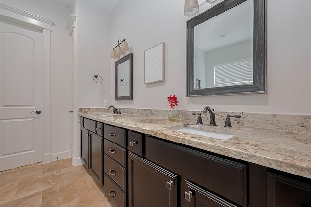 full bath featuring double vanity, a sink, and stone finish floor