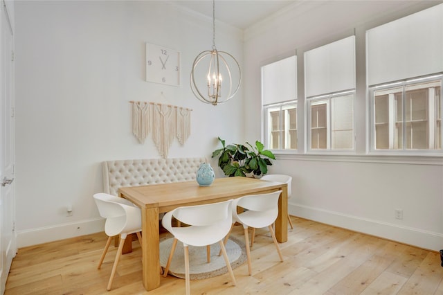 dining area with crown molding, baseboards, light wood-style flooring, and a chandelier