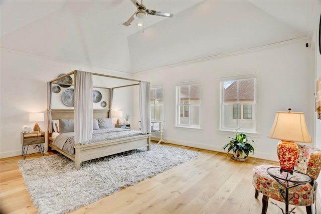 bedroom with baseboards, a ceiling fan, wood finished floors, and high vaulted ceiling
