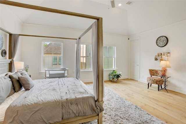 bedroom featuring baseboards, visible vents, wood finished floors, and vaulted ceiling