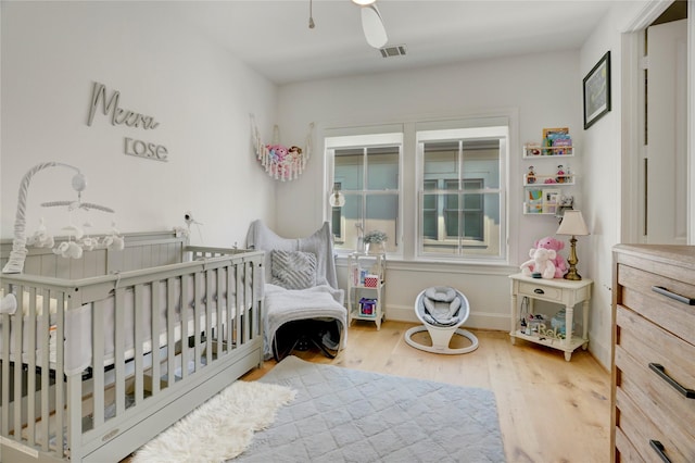 bedroom featuring baseboards, a ceiling fan, wood finished floors, and visible vents
