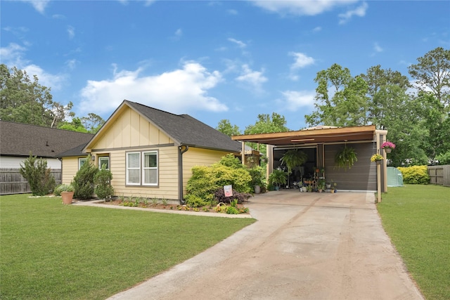 view of front facade with board and batten siding, fence, a front yard, and concrete driveway