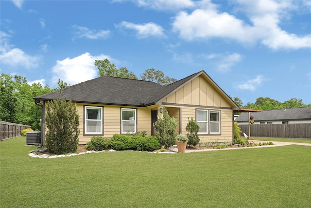 single story home featuring fence, board and batten siding, a shingled roof, and a front yard
