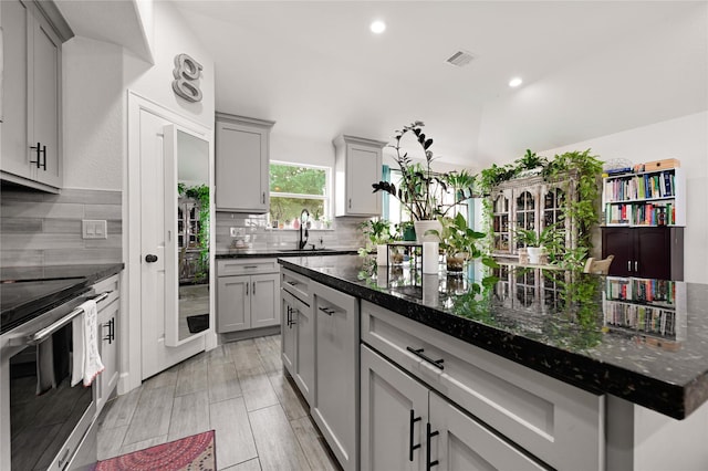 kitchen with a sink, gray cabinets, visible vents, and stainless steel electric stove