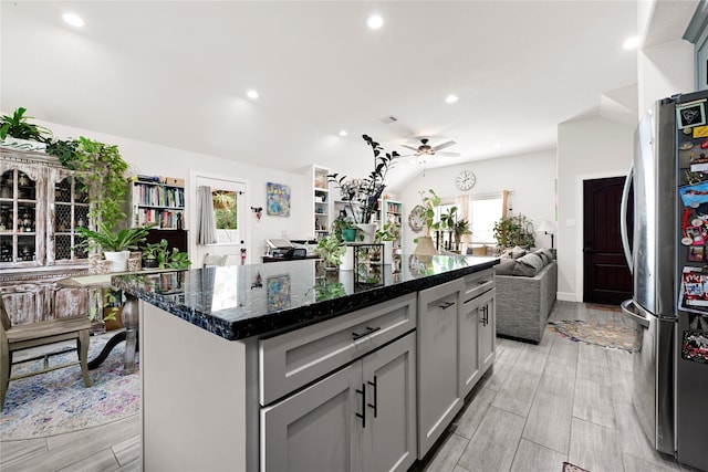 kitchen with ceiling fan, a kitchen island, gray cabinetry, freestanding refrigerator, and open floor plan