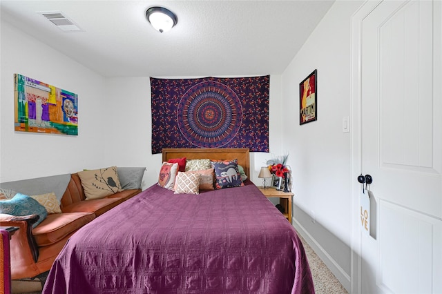 carpeted bedroom with visible vents and baseboards