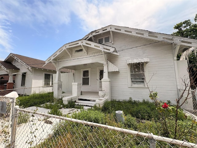 view of front of house featuring a porch and fence private yard