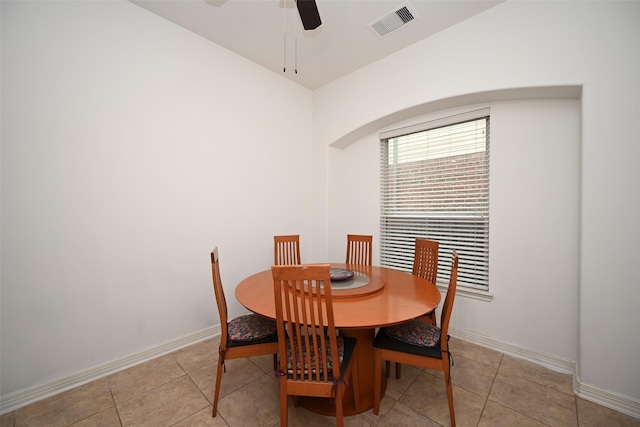 tiled dining space featuring visible vents, a ceiling fan, baseboards, and arched walkways