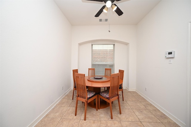 dining room with a ceiling fan, arched walkways, visible vents, and baseboards