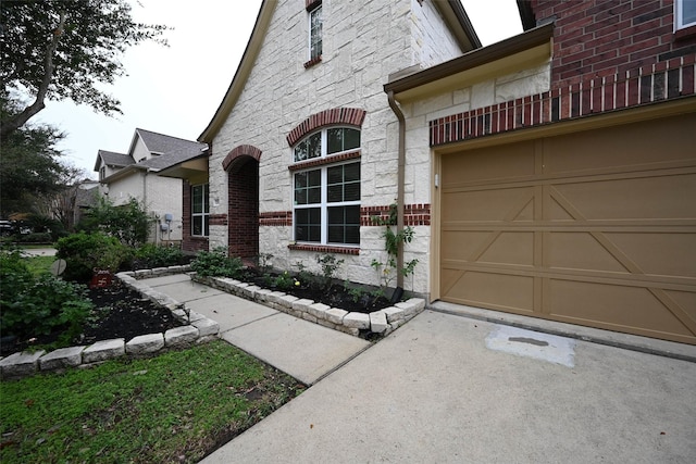view of front of house with driveway and stone siding