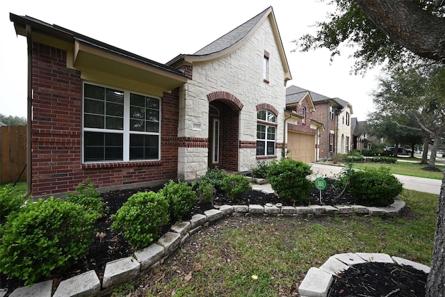 view of front facade with brick siding, a garage, and stone siding