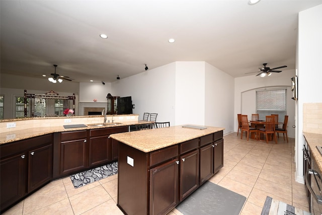 kitchen with a sink, light tile patterned floors, and a ceiling fan