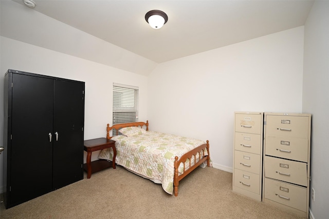 bedroom with baseboards, light colored carpet, and vaulted ceiling