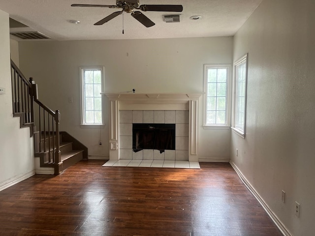 unfurnished living room featuring a ceiling fan, stairs, hardwood / wood-style floors, and visible vents