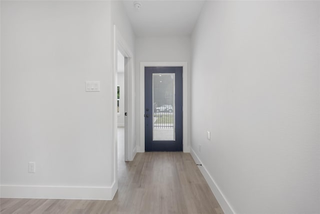doorway featuring baseboards and light wood-style flooring