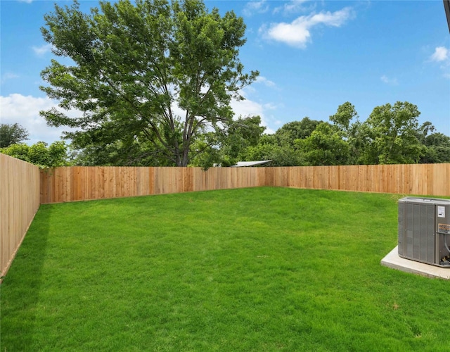 view of yard with a fenced backyard and central AC