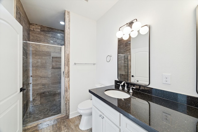 full bath featuring vanity, a stall shower, and toilet
