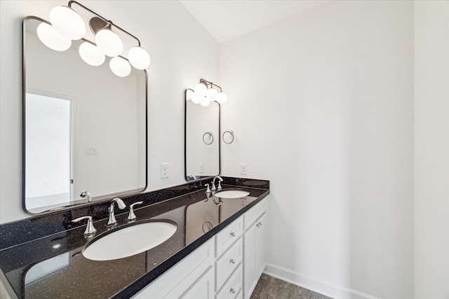 bathroom featuring double vanity, a sink, and baseboards