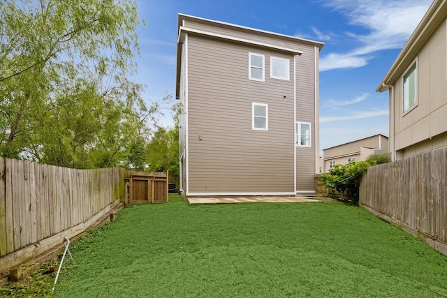 back of property featuring a lawn and a fenced backyard