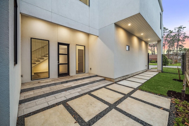exterior space with stucco siding and fence