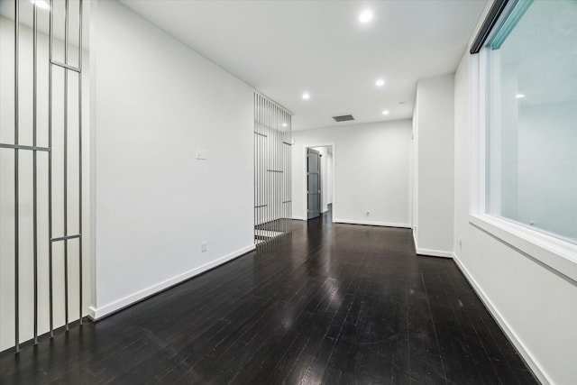 spare room featuring recessed lighting, baseboards, hardwood / wood-style flooring, and visible vents