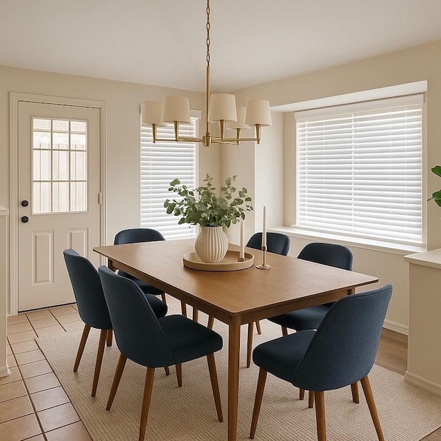 dining area featuring an inviting chandelier, baseboards, and light tile patterned floors