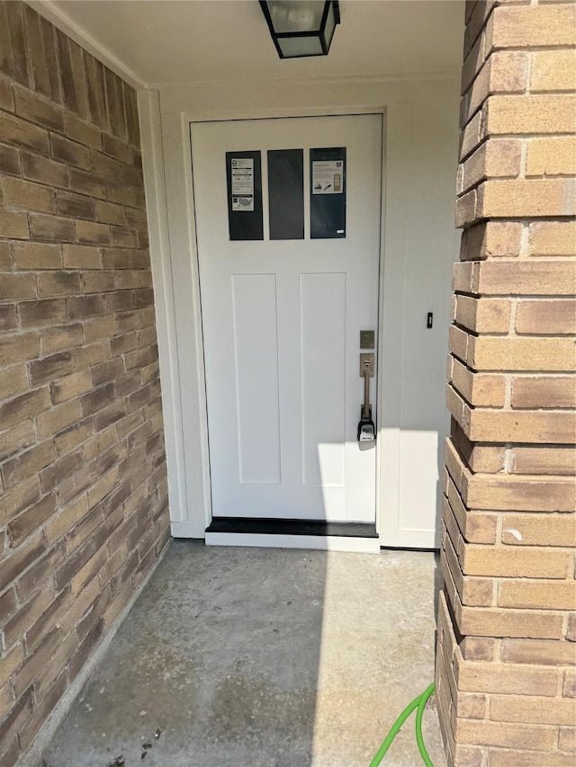 view of exterior entry featuring brick siding