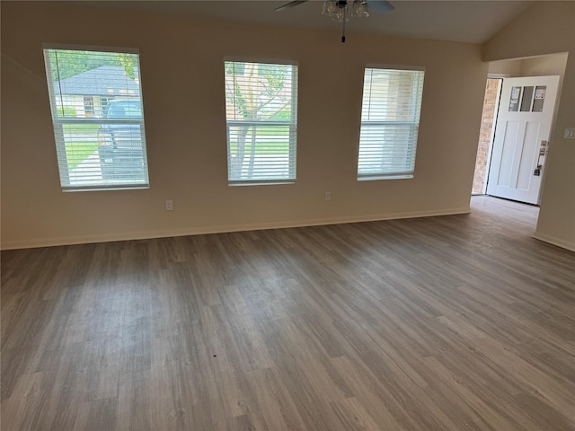 unfurnished living room with baseboards, ceiling fan, a wealth of natural light, and wood finished floors