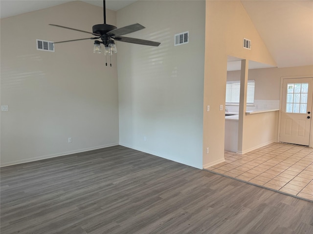 empty room featuring a ceiling fan, baseboards, visible vents, and wood finished floors