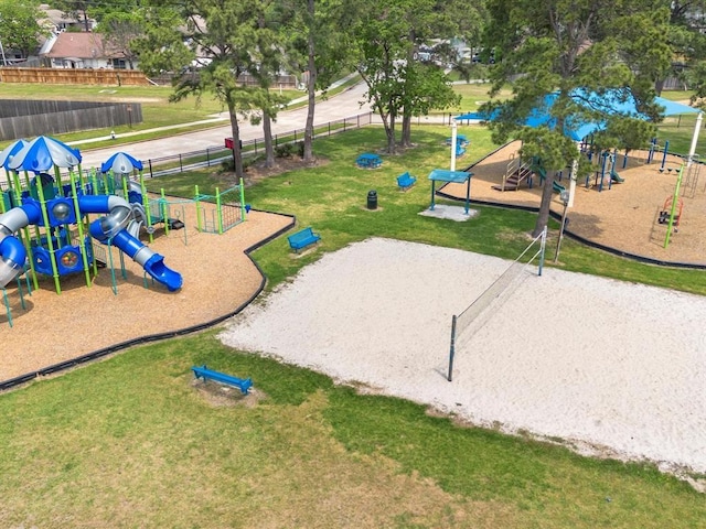 view of community featuring a lawn, fence, and playground community