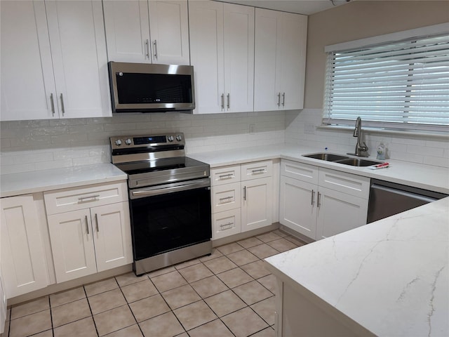 kitchen featuring a sink, white cabinets, stainless steel appliances, and tasteful backsplash
