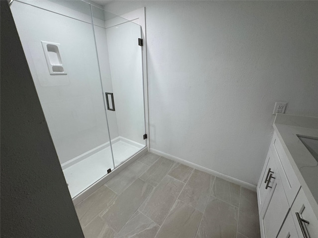 bathroom featuring baseboards and a shower stall