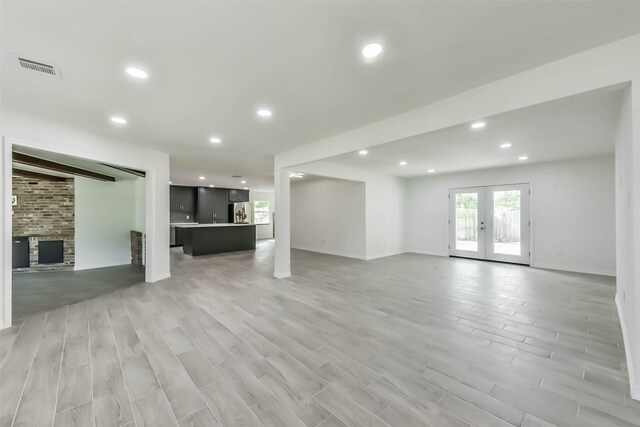 22 13th Ave N, Texas City, TX 77590 - unfurnished living room featuring visible vents, a brick fireplace, light wood-type flooring, recessed lighting, and french doors