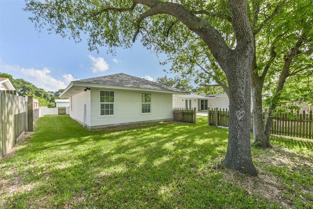 22 13th Ave N, Texas City, TX 77590 - rear view of house with a lawn, a shingled roof, and a fenced backyard