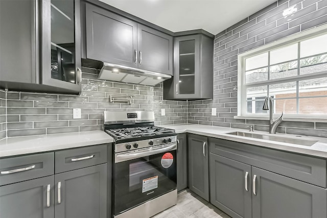 22 13th Ave N, Texas City, TX 77590 - kitchen featuring stainless steel gas range oven, light countertops, gray cabinets, under cabinet range hood, and a sink