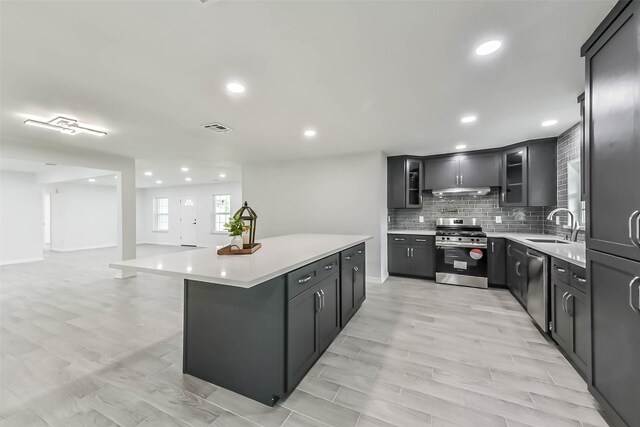 22 13th Ave N, Texas City, TX 77590 - kitchen with tasteful backsplash, a sink, light countertops, glass insert cabinets, and stainless steel appliances